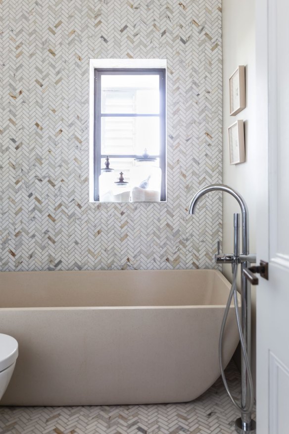 “I love a bath,” says Heidi. “The marble tiles are laid in a herringbone pattern on the walls and floor, echoing the wooden parquetry throughout the rest of the apartment.”