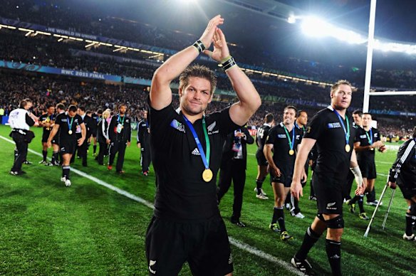 Richie McCaw leads the All Blacks on a lap of honour.
