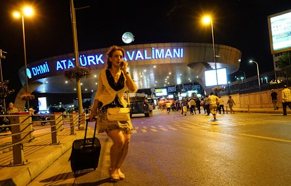 A passenger walks away as Turkish army's tanks enter the Ataturk Airport.