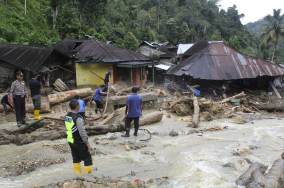 Rescuers search for victims following a flash flood in Mandailing Natal district.