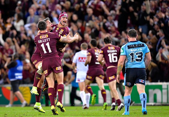 Johnathan Thurston, Corey Parker and Matt Gillett of the Maroons celebrate victory as Paul Gallen of the Blues is dejected after game two