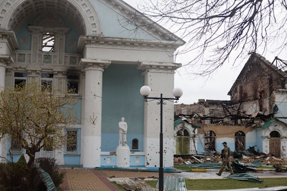 Ukrainian servicemen patrol the area of a shelled community center in Irpin, Ukraine.