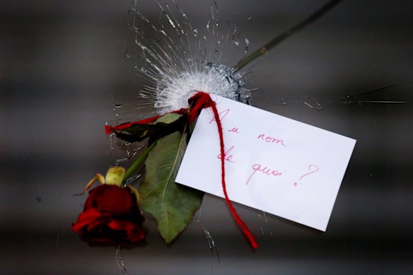 A rose in a bullet hole with a note that translates to "In the name of what?" at La Belle Equipe in Paris.