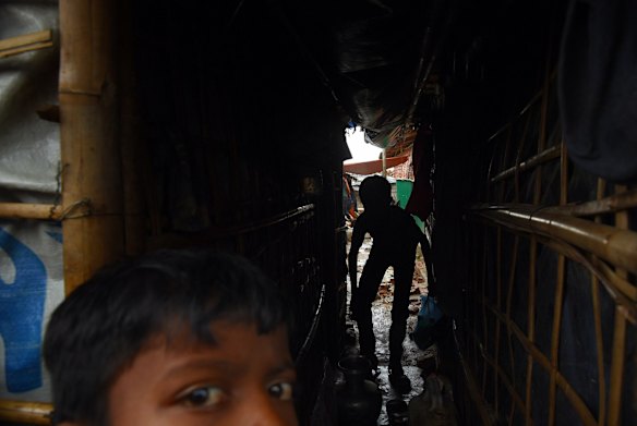 Rohingya children take shelter from the rain in Kutupalong Camp. 