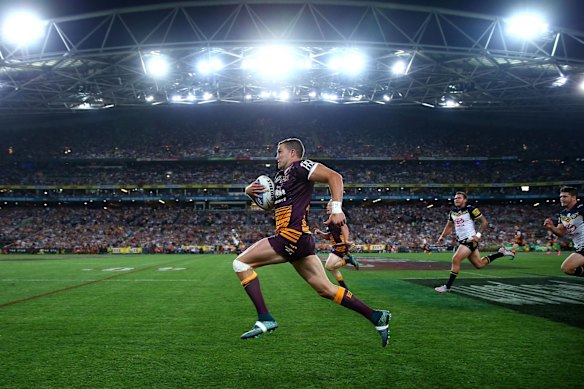 Corey Oates of the Broncos makes a break to score a try.