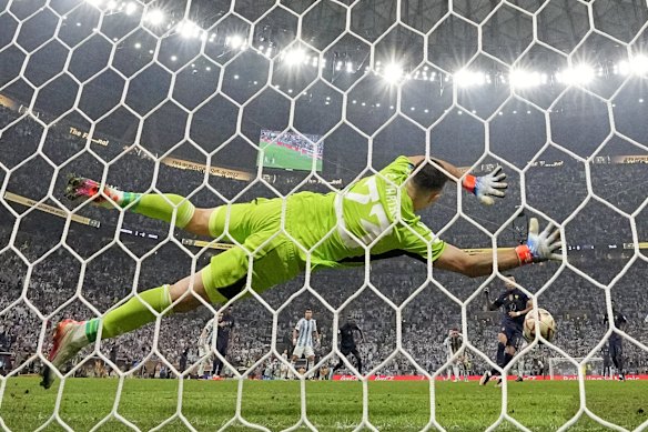 Argentina's goalkeeper Emiliano Martinez can't stop Kylian Mbappe's penalty.