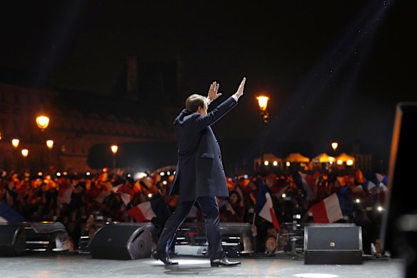 French President-elect Emmanuel Macron arrives on the stage at his victory rally near the Louvre museum.