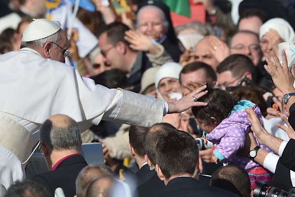 Pope Francis blesses a little girl in the crowd from the papamobile during his inauguration mass.
