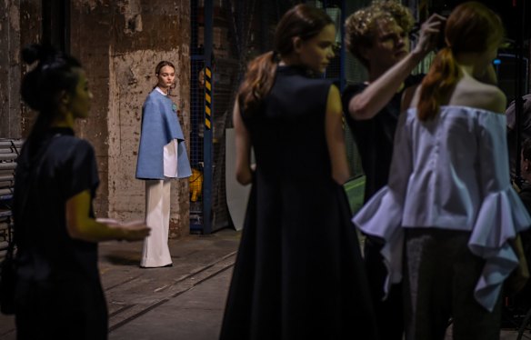 Models await their turn whilst last minute adjustments are also made backstage.