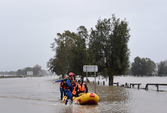 SES rescuers make their way through the floodwaters in Shoalhaven Heads, NSW.