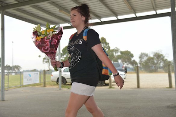 Friends arrive at the Tyabb oval to place flowers.