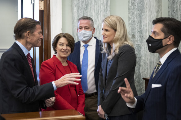 Democrat Senators Richard Blumenthal, left, and Amy Klobuchar speak with former Facebook employee and whistleblower Frances Haugen, right, as she arrives to testify in the Senate in Washington. 
