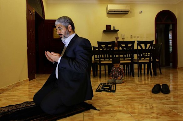 Khalid Mishal prays with his grandson Saad 2yrs (right) at a house in Doha, Qatar.