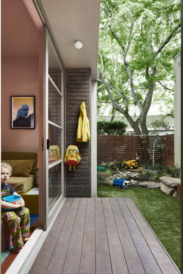 A deck connects the former garage to the front courtyard, and a rockery under the shade of a Gleditsia tree is the perfect creative outdoor play space.