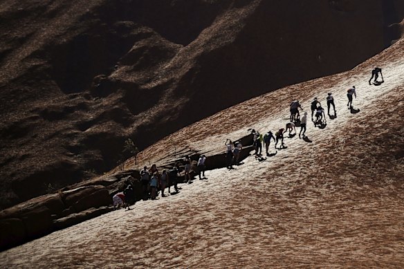 Visitors climbing up Uluru on the final day the climb is allowed.