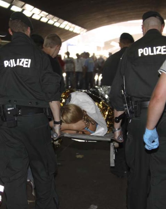 Medics evacuate an injured person from a tunnel after a stampede killed up to 18 people during a festival in Duisburg, Germany.