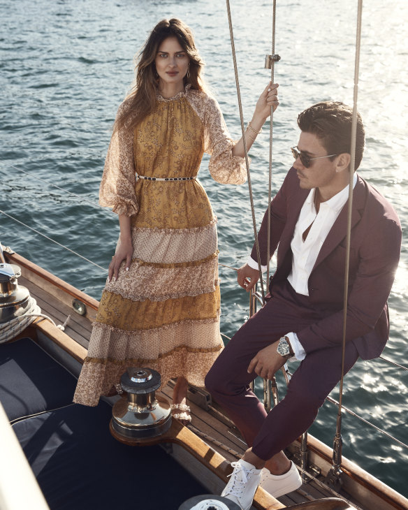 She wears Tigerlily “Emica” maxi dress, $299; Zara slides, $90; David Yurman earrings and bracelets, from Fairfax & Roberts, as before. He wears BOSS suit jacket, $779, and trousers, $319; M.J. Bale “Sidgwick” Oxford shirt, $130; Longines “HydroConquest” watch, $2400; R.M. Williams “Surry” sneakers, $295; and Hugo Boss sunglasses, $264.