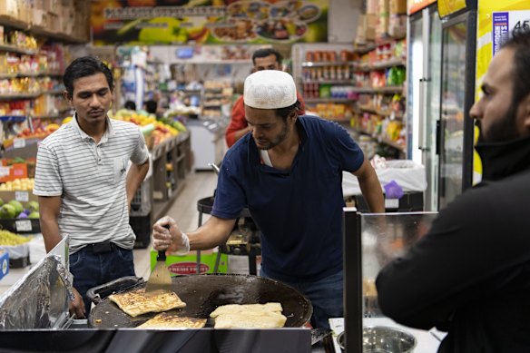 A shopowner prepares a customer's order in Lakemba.