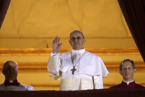 Pope Francis waves to the crowd from the central balcony of St. Peter's Basilica at the Vatican.