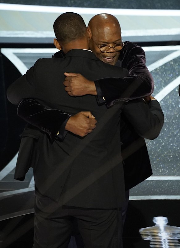 Will Smith, left, and Samuel L. Jackson hug in the audience as Will Smith is announced the winner of the award for best performance by an actor in a leading role for "King Richard".