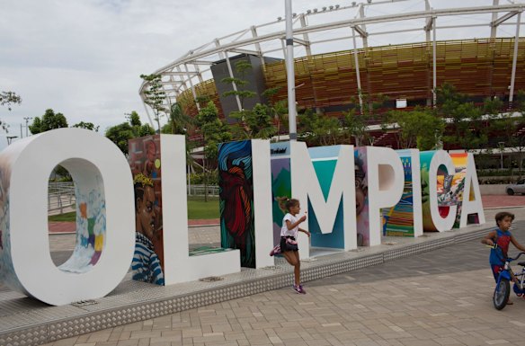 Children play near the Olympic Park sign. The city spend about $US12 billion to organise the Games sill plagued by reports of bribes and corruption linked to the building of some  facilities. 