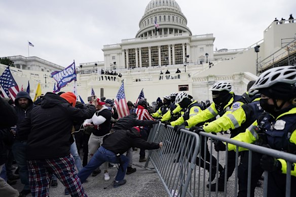 Trump supporters try to break through a police barrier at the Capitol in Washington.