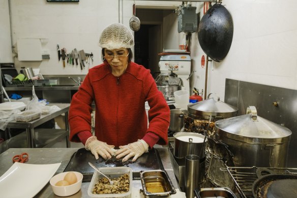 Kim Thanh cooking in her son Anthony Dinh's Vietnamese restaurant.