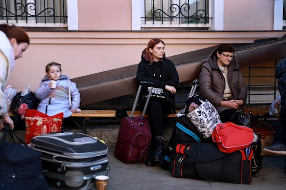 Yesenia Jasko, Ola Kuchrenky, and Tatiana Kuchrenky sit together after fleeing their homes by train to Lviv. 