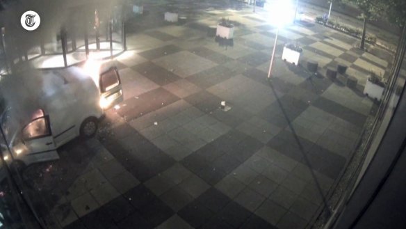 This image taken from a security camera video shows a van on fire outside the newspaper building. 