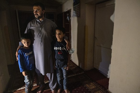 Yousef Mohammed, 35, stands with his two sons at his home using a gas lamp during one of the many power outages on July 30, 2021 in Kabul, Afghanistan. He worked as a combat translator for the US army for 5 years from 2008-2013 in Laghman province, and says that when he requested a non-combat mission fearing for his life he was terminated. Thousands of Afghans who worked for the United States government during its nearly 20-year war here now fear for their safety as the US withdraws its troops from the country. Many of these Afghans, who worked as interpreters and translators for US intelligence agencies and military branches, have applied to come to the US as part of the Special Immigrant Visa (SIV) program, with the first such group arriving in the US last month. But, for most SIV candidates, the timeline for relocation remains unknown.