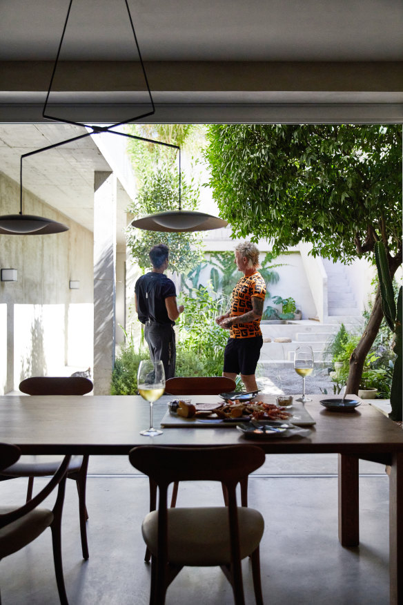 The couple looking out at their garden. “Neighbours share stories about the house and those who have lived in it before us,” says Chard. “We feel part of its history.”