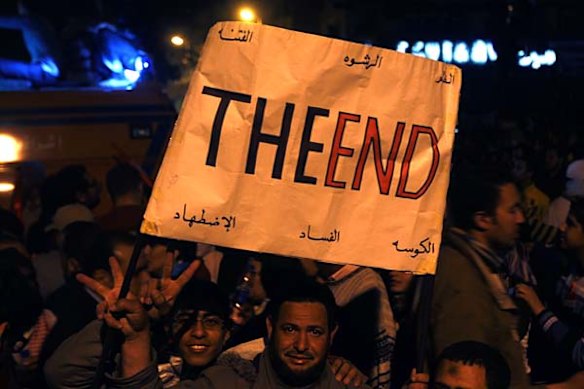 Anti-government protesters carry a placard and celebrate in Tahrir square in Cairo.