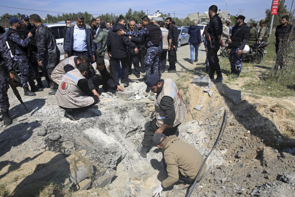 Hamas security services personnel inspect the site of the explosion.