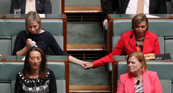 Susan Lamb holds hands with Anne Aly as Opposition Leader Bill Shorten delivered a statement to the House about the death of Binni Kirkbright-Burney the son of MP Linda Burney during question time at Parliament House in Canberra on Wednesday 25 October 2017.
