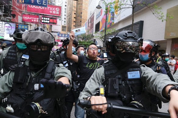 Tam Tak-chi, vice chairman of the People Power party, center, is led away by riot police during a protest against a planned national security law in the Causeway Bay district in Hong Kong, China.