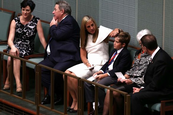 Xavier Hockey gets his hair combed by his mum, Melissa Babbage, as they wait to watch Treasurer Joe Hockey hand down the Budge.