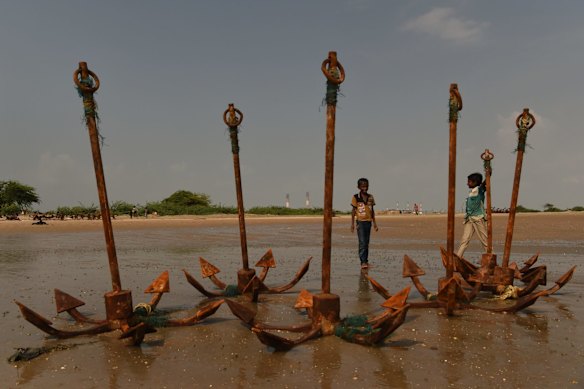 Children play among anchors near the Tragadi Bandar fishing settlement, on the Kutch coast in Gujarat state, India.