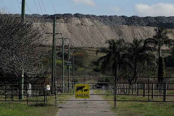 A sign indicating cattle in the area attached to a gate on a property with a section of the Mount Pleasant mine in the background. The future of mining and agriculture are two of the top topics being discussed by candidates and the public in the upcoming Upper Hunter by-election.