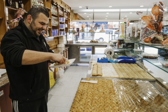 Mohammad El Basha samples a dessert in between customers at the Chehade El Bahsa & Sons Sweets shop.