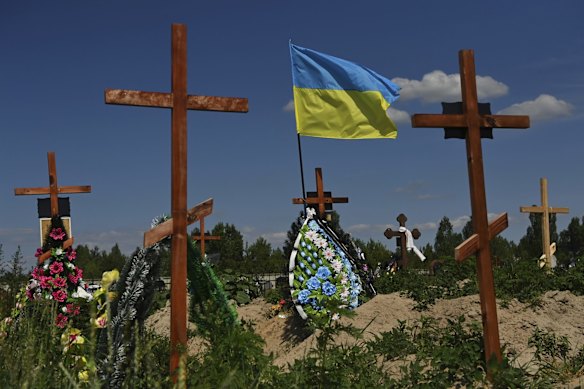 The Ukrainian flag flies above graves at the new cemetery in Bucha, 30 kilometres north-west of Kyiv. More than 1300 civilians in Bucha and surrounding areas were killed by Russian soldiers when they occupied the town from March 4 to March 31. 