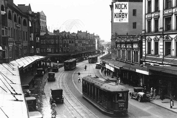 A view of George Street from Grosvenor Street, looking northward to the Sydney Harbour Bridge that is under construction, 1931.