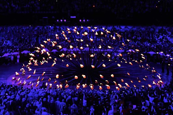 The cauldron is spectacularly lit by the Olympic flame.