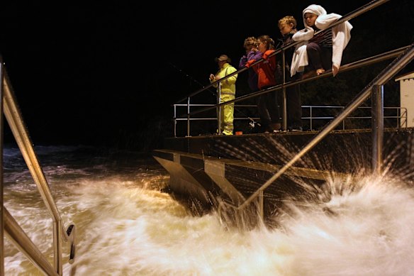 The high tide and huge swell drives waves up to the promenade at Austinmer beach. 