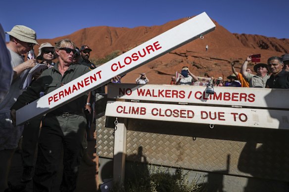 Ranger Lynda Wright places the new sign of the permanent closure of the Uluru climb.