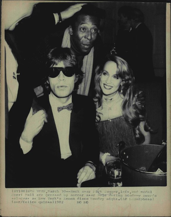 Rock star Mick Jagger, left, and model Jerri Hall are grested by soccer star Pele during Academy Awards telecast at New York's Xenon disco. 1982.