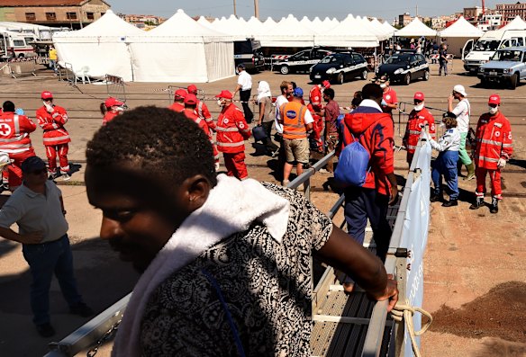 Some of the 415 people rescued off the Libyan coast by the Migrant Offshore Aid Station (MOAS) supported by Medecins Sans Frontieres (MSF) on the MY Phoenix disembark in Taranto, Italy.