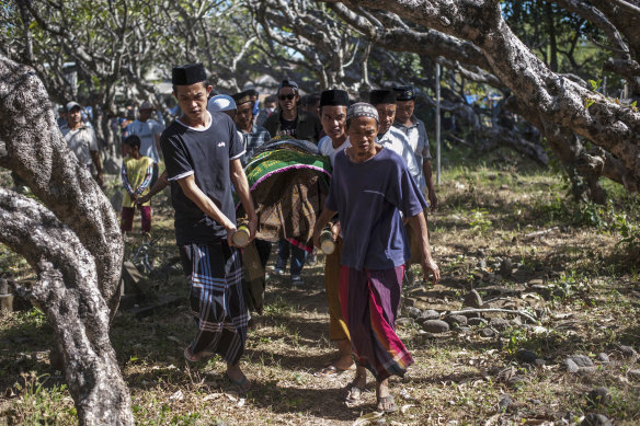 Men carry the body of a victim of last week's earthquake during a burial in Gangga, Lombok Island, Indonesia.