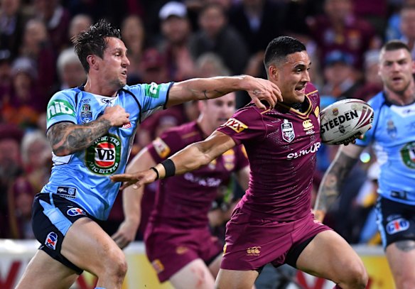 Left behind: Valentine Holmes of the Maroons gets past Mitchell Pearce.