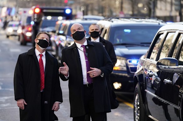 Security look upward as Vice President Kamala Harris, and her husband Doug Emhoff, ride during the Inauguration Day Parade Route in Washington, Wednesday, Jan. 20, 2021, after being sworn in as the 46th vice president of the United States.