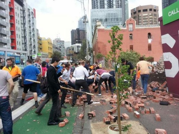 People rush to the scene of the wall collapse.